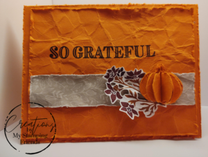 Orange card with a 3-D paper pumpkin on a floral image with the sentiment, 'So Grateful'