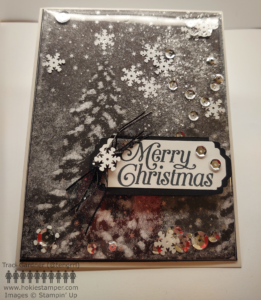 Christmas card with black and white illustration of snowy trees and a snowy sky with silver sequins and white snowflake-shaped sequins. The sentiment is Merry Christmas.