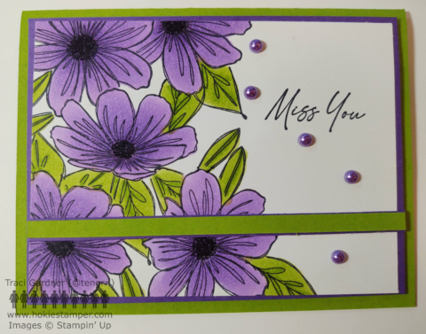 Purple flowers with bright green leaves on a green greeting card base, with the sentiment, Miss You