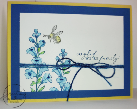 Card showing a honeybee pollenating blue flowers, with the sentiment, So Glad We're Family
