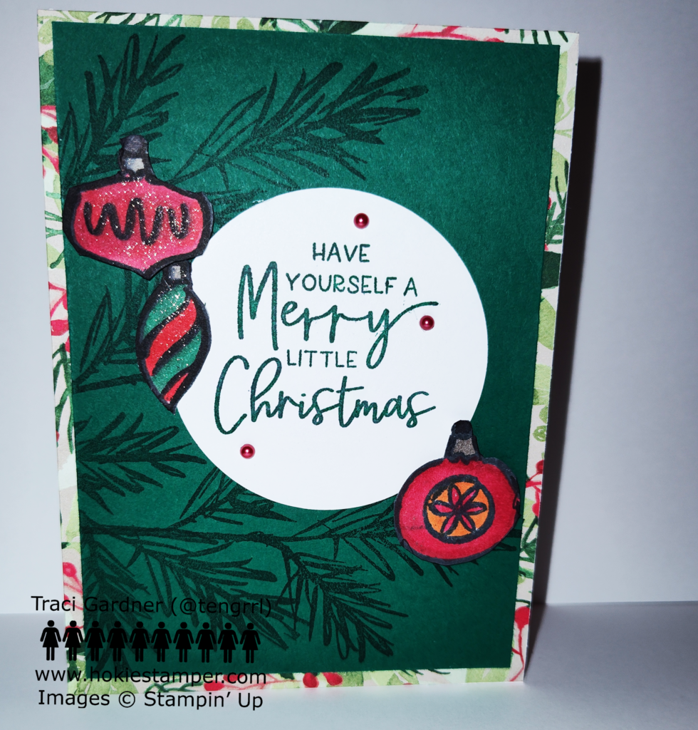 Christmas card with pine branches on a dark green background. The focal image is a white circle with the sentiment Have yourself a merry little Christmas. The circle is surrounded by Christmas ornaments.
